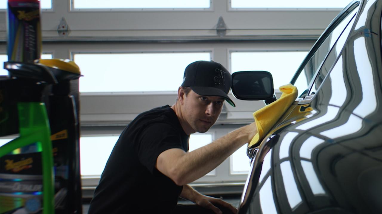 TJ Hunt wiping down the side of a car