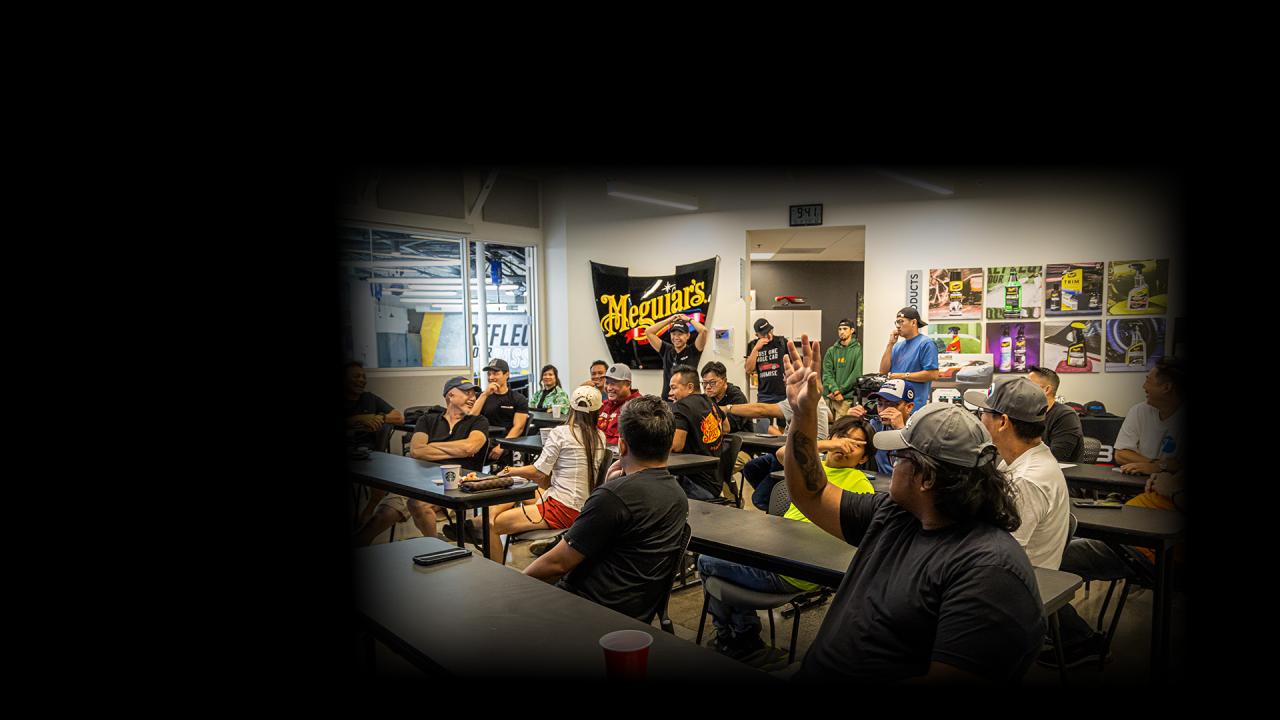 People sitting at desks in an automotive detailing training room