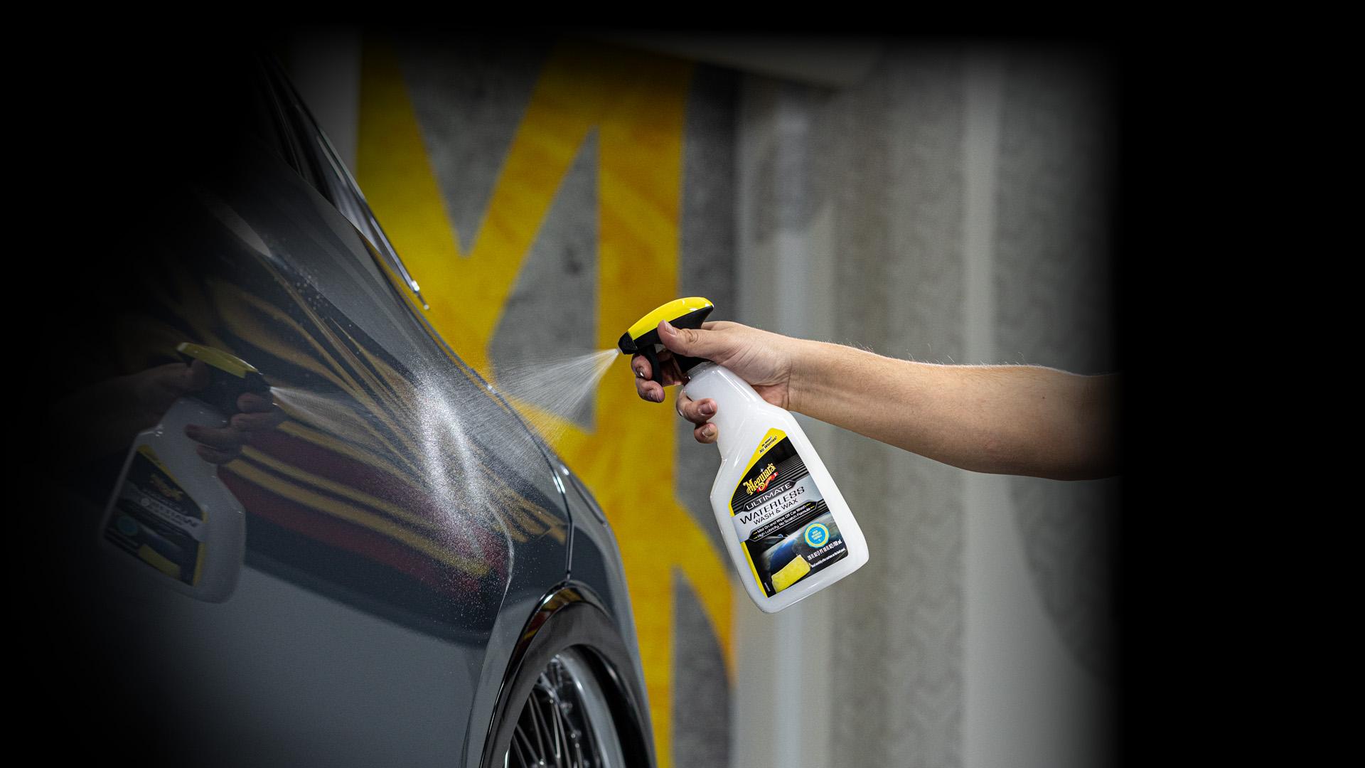 Meguiar's product being sprayed on a black car