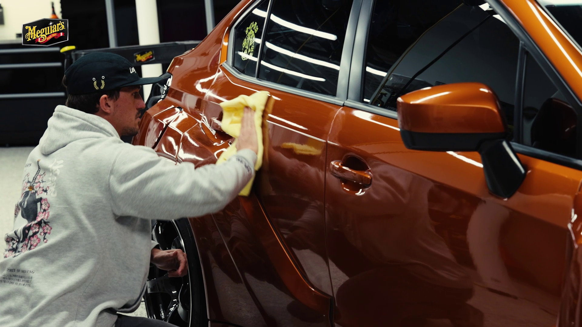 Dustin Williams Wiping down the side panel of a car