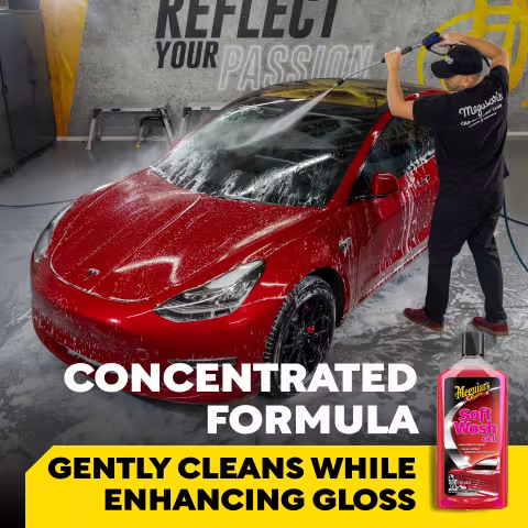 Meguiar’s Soft Wash Gel promotional image showing a red Tesla being rinsed with a pressure washer in a detailing garage. Wall text reads “REFLECT YOUR PASSION.” Large text reads “CONCENTRATED FORMULA” and “GENTLY CLEANS WHILE ENHANCING GLOSS.” A bottle of Meguiar’s Soft Wash Gel appears in the lower right corner.
